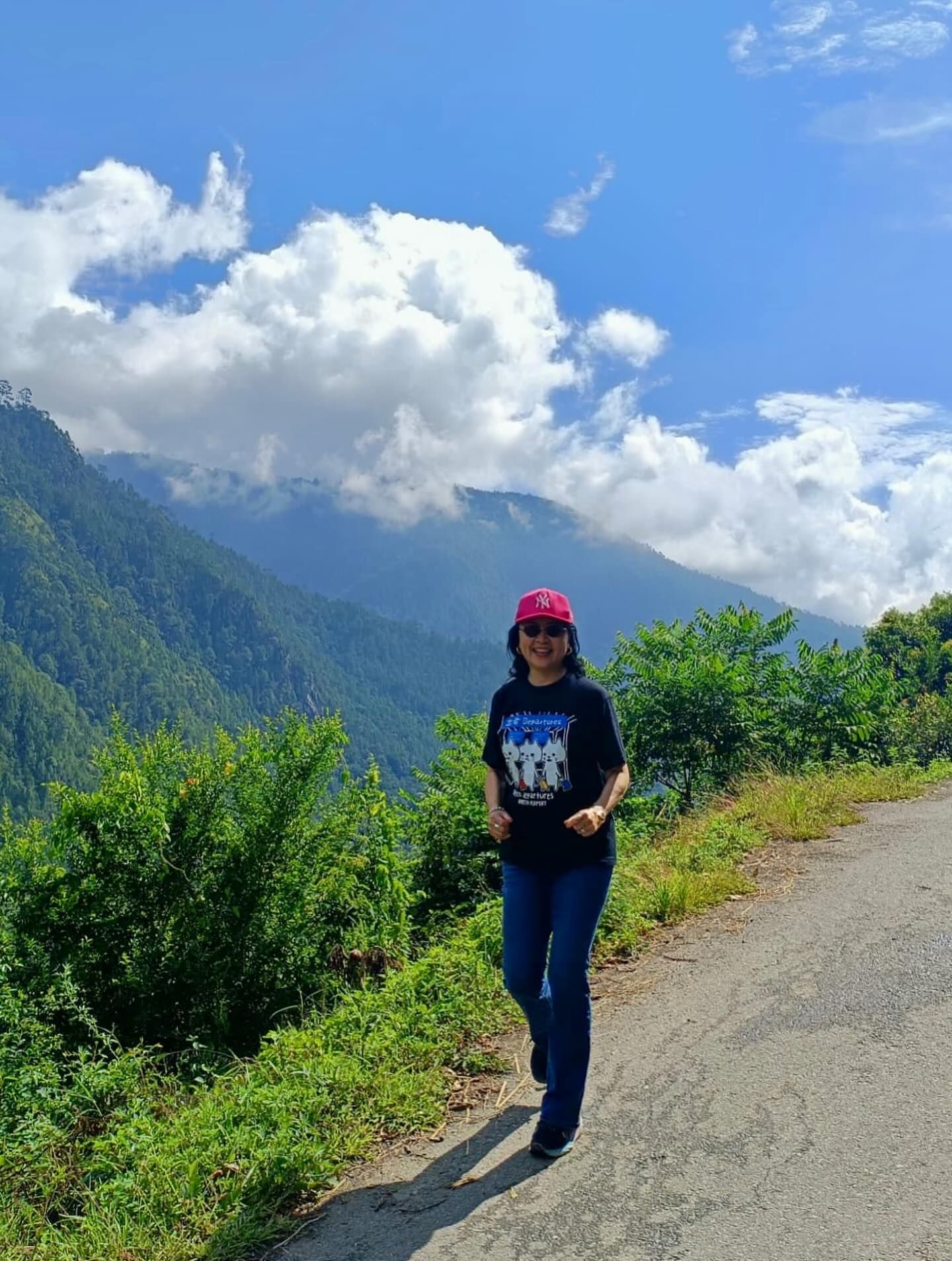 1人、道路、山、雲の画像のようです