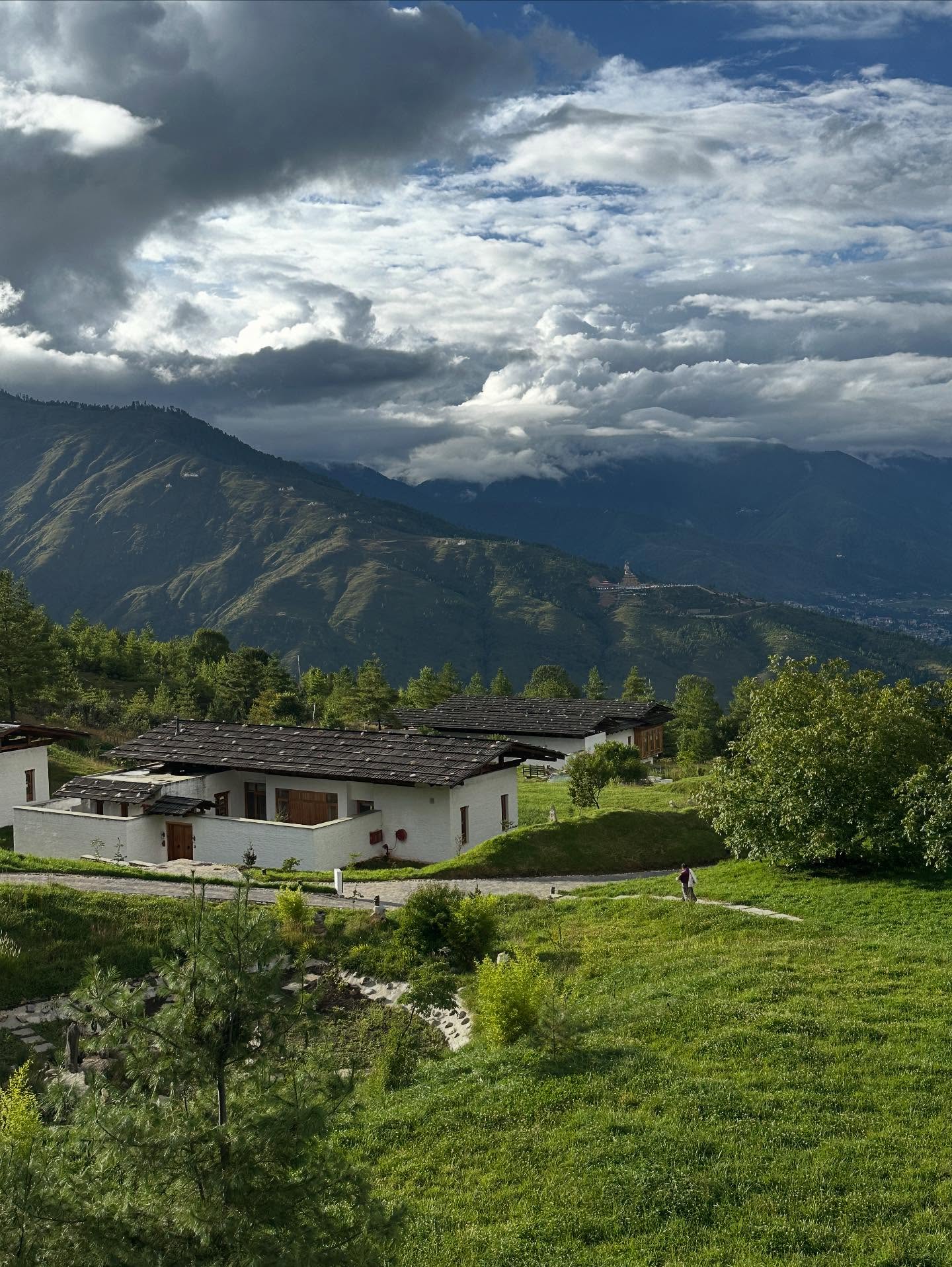 1人、草、雲、山の画像のようです